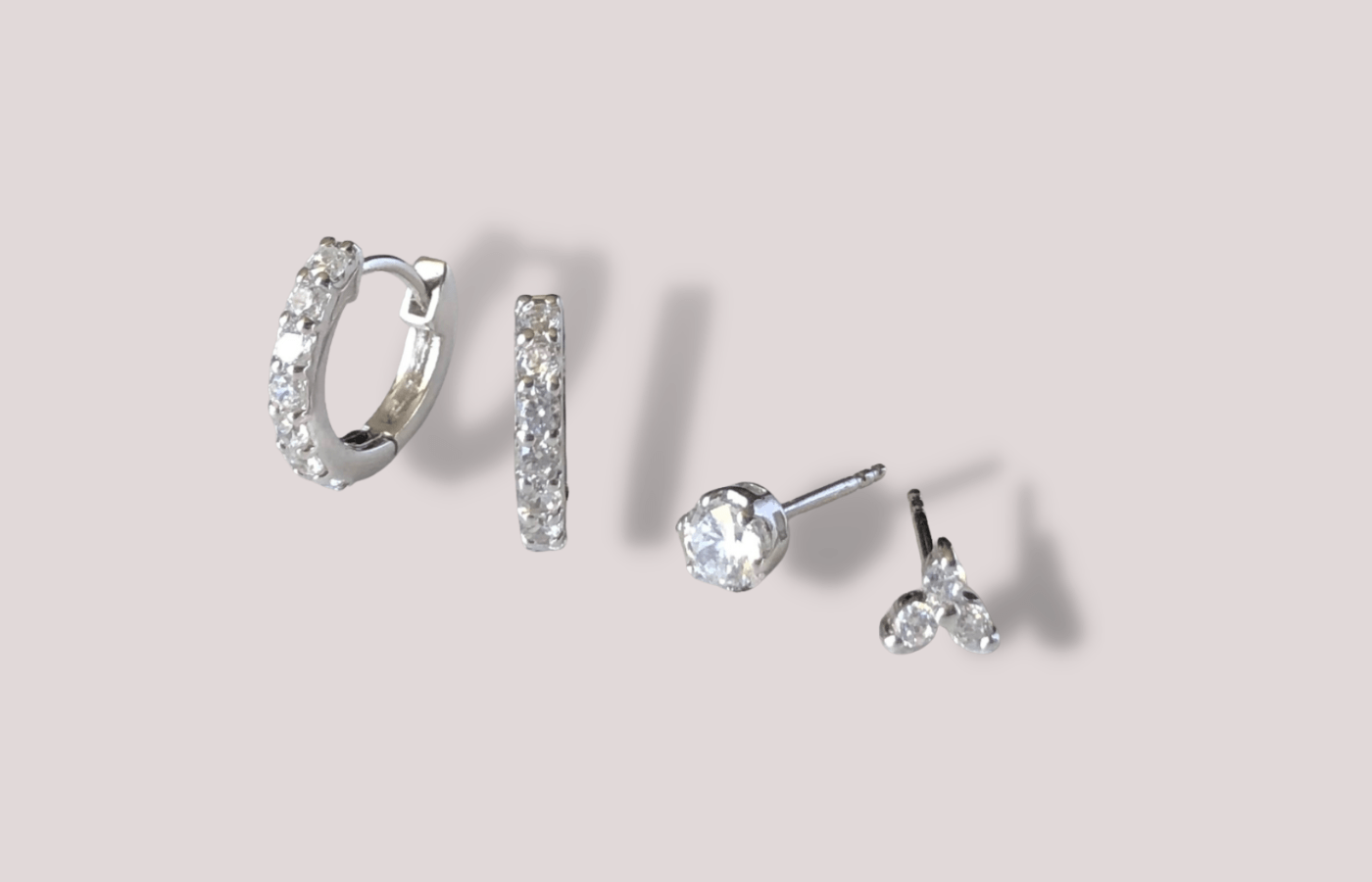 sparkling diamond simulant earrings on beige background