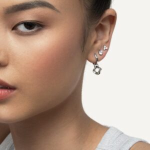Model wearing earring stack with silver hoop charm.