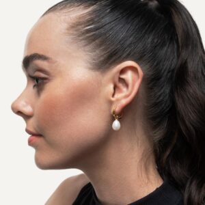 Hoop earrings with pearl charm on dark haired model.