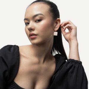 Square gemstone dangle earrings on model wearing a black top.