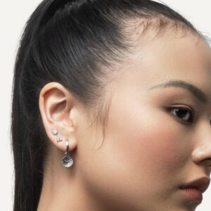Diamond simulant stud earrings in ear stack on model.