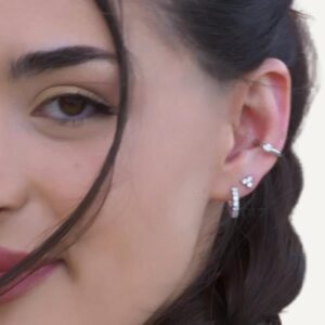 Diamond simulant earring stack including ear cuff on dark haired model.