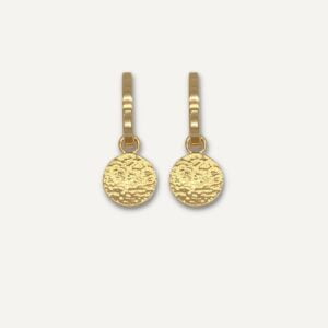 Hoop earrings with charm on cream background.