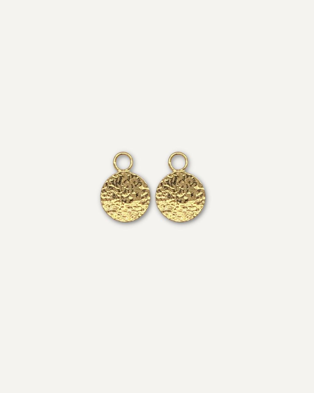 Removable earring charms with hammered finish on cream background.