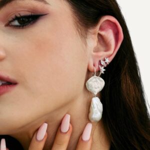 Silver earring stack on model of diamond simulant earrings.