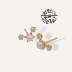 Diamond simulant and pearl stud earrings on cream background.