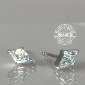 Kite shaped diamond simulant stud earrings on grey background.