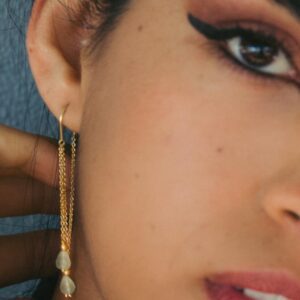 Threader earring with gemstone drop on model.