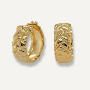 Chunky hoop earrings with surface design of tyre track in gold on cream background.