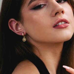 Hoop earrings with charm on model.
